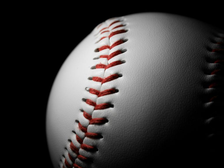 White leather baseball isolated on black with spotlight on it. Sports concept.